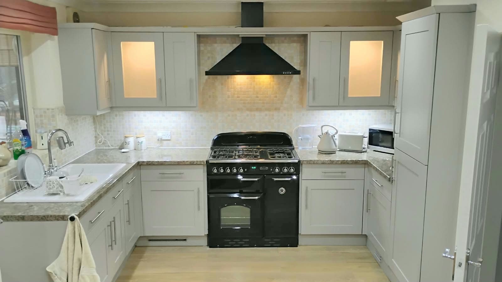 The same shaker kitchen resprayed light grey, with the range cooker fronts sprayed gloss black