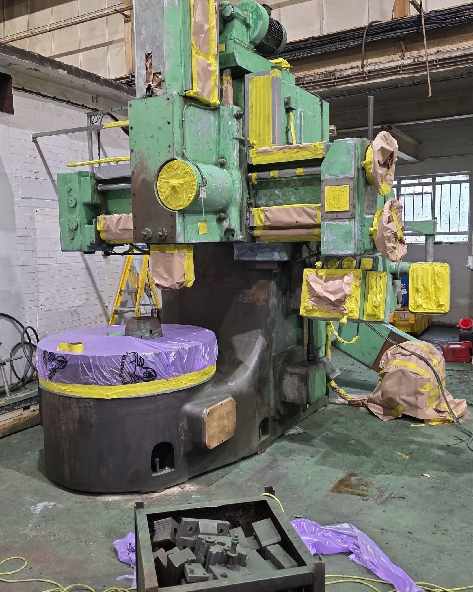 Webster & Bennett vertical boring machine in worn green paint, masked with tape and paper before spraying