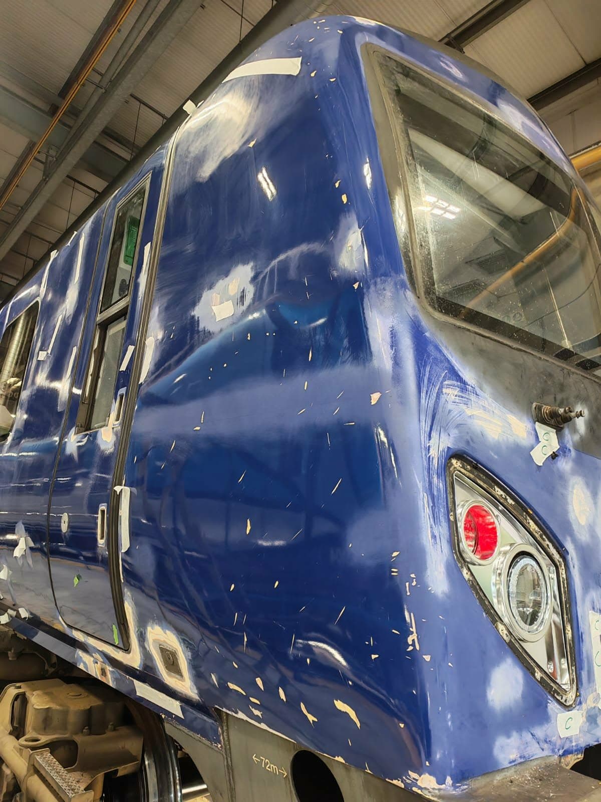 Blue train cab end flatted, filled and masked in a depot, ready for spraying